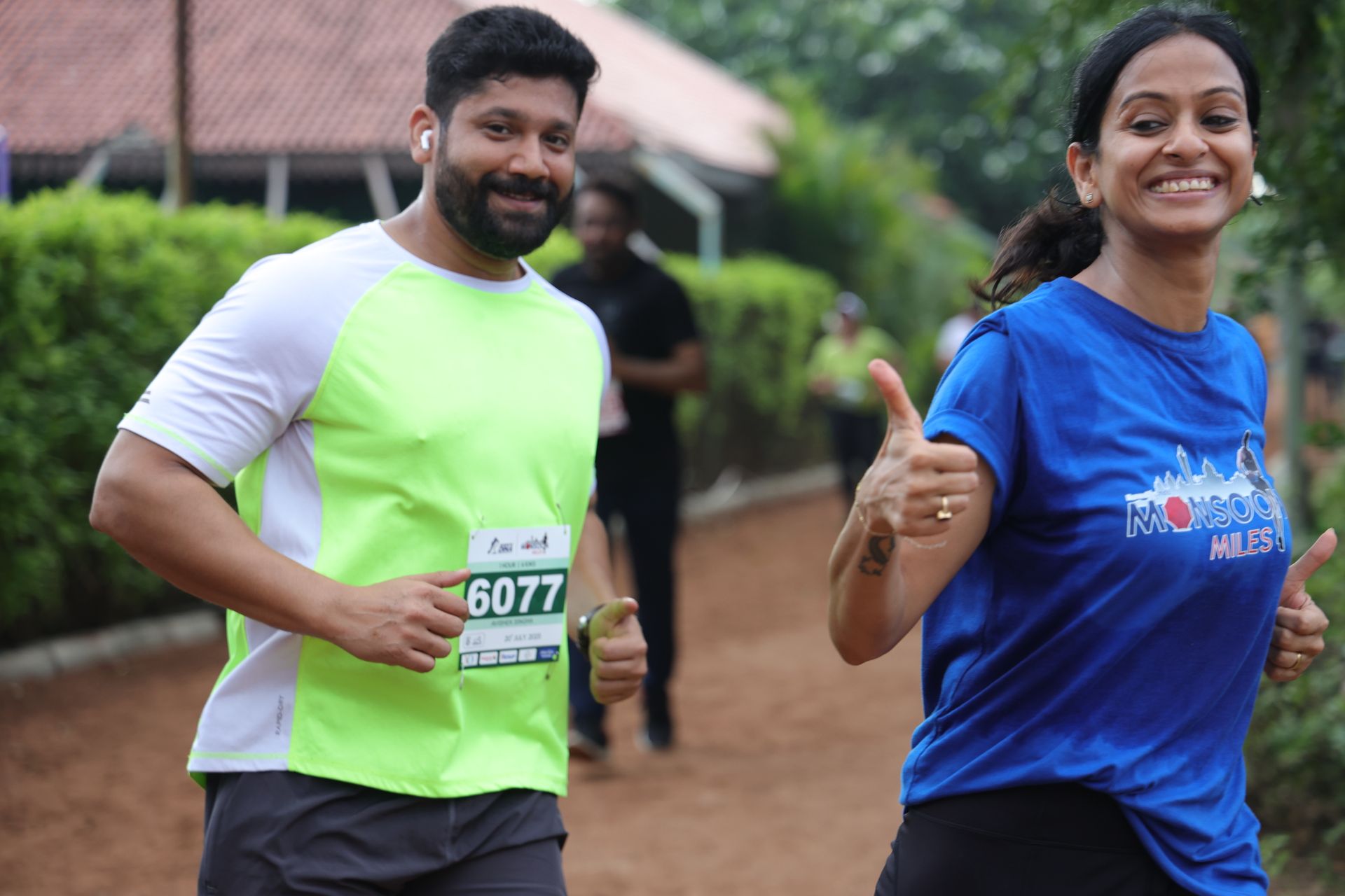 Two runners giving thumbs up on trail